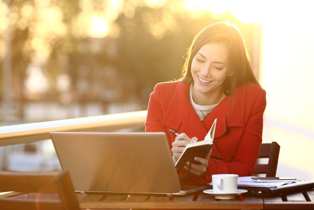 uma mulher sentada em uma mesa em frente a um laptop