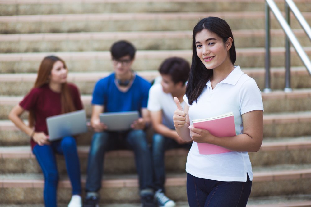 um grupo de pessoas sentadas em degraus com laptops