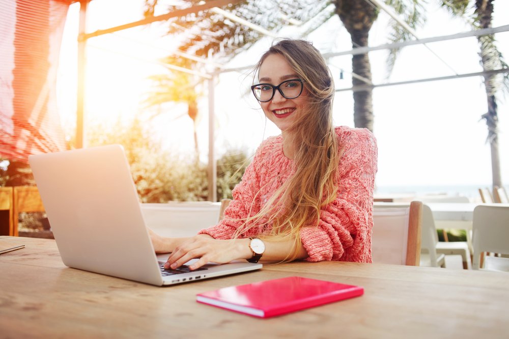 uma mulher sentada em uma mesa usando um laptop