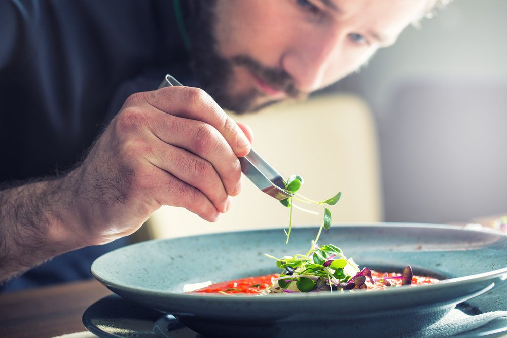 um homem com uma faca e um garfo em uma tigela de comida