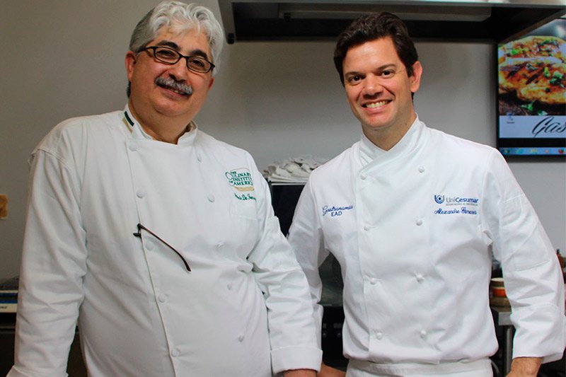 dois homens parados um ao lado do outro em uma cozinha