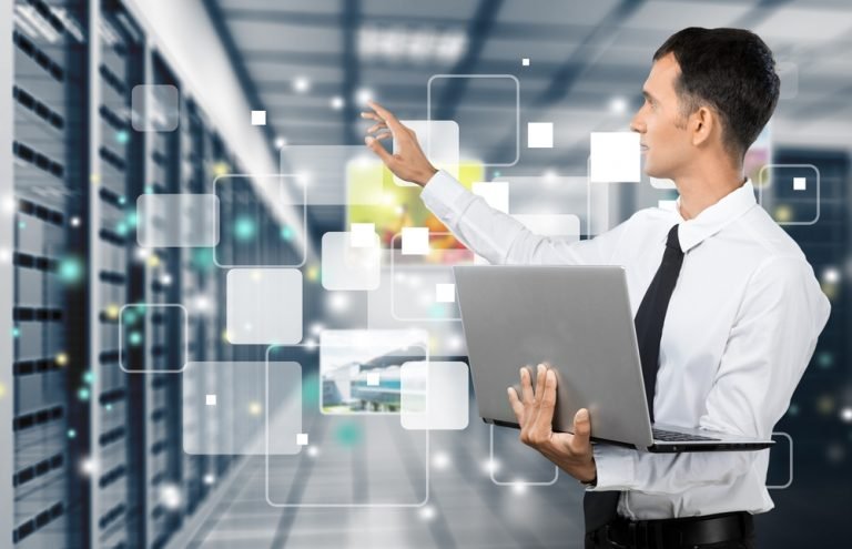 um homem de camisa branca e gravata segurando um laptop