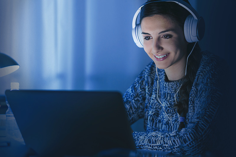 uma mulher usando fones de ouvido e um laptop