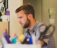 um homem sentado em uma mesa com um laptop