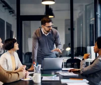 Reunião de negócios com equipe diversa discutindo estratégias em escritório moderno, foco na palavra-chave 'consultoria de negócios'