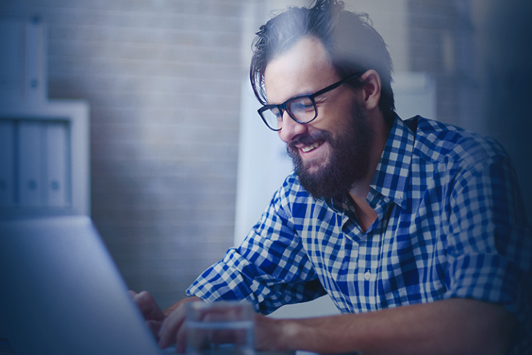 um homem sentado em uma mesa usando um laptop
