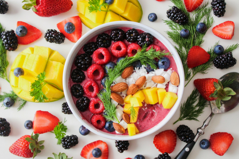 uma tigela cheia de frutas e nozes em cima de uma mesa