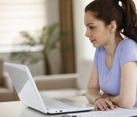 uma mulher sentada em frente a um laptop