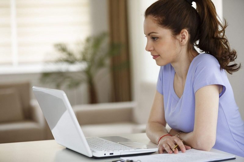 uma mulher sentada em frente a um laptop