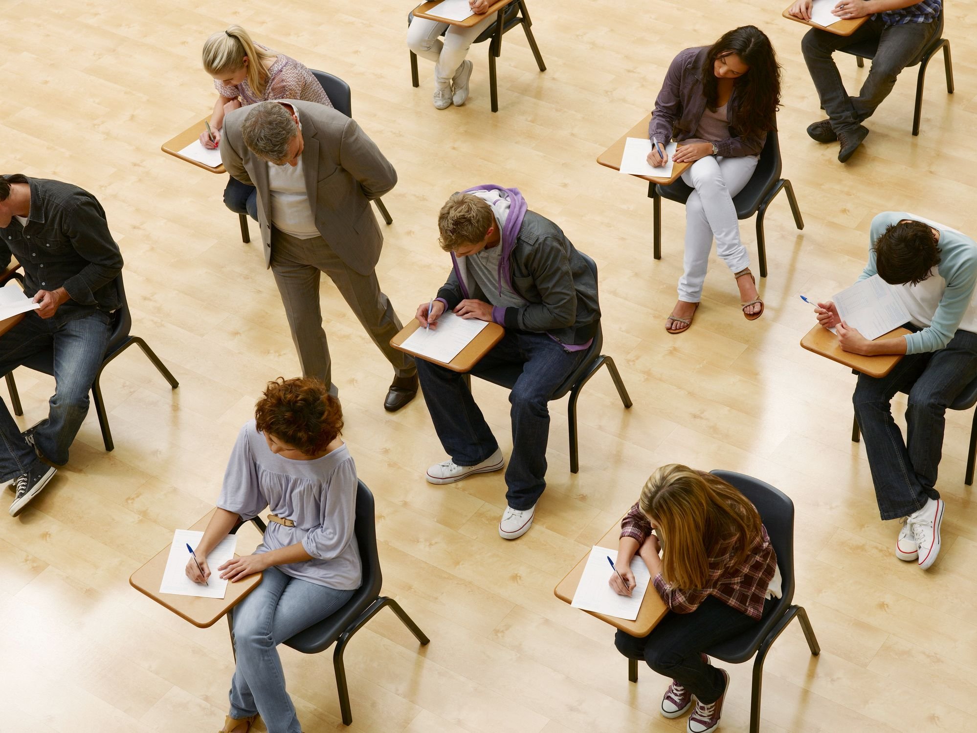 Grupo de estudantes realizando uma prova em sala de aula, com foco no processo de aprendizado e concentração dos alunos durante o exame.