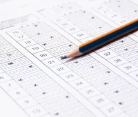 Imagem de uma folha de testes de múltipla escolha com marcações feitas com um lápis azul e borracha, relacionada a avaliação de conhecimentos. Ideal para dicas de estudo e preparação para provas.