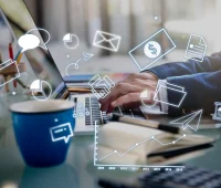 Pessoa trabalhando em um computador com gráficos, ícones de comunicação e dados tecnológicos flutuando ao redor, simbolizando produtividade, tecnologia e comunicação digital.