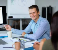 Profissional de gestão financeira apresentando dados e gráficos em reunião de negócios, discutindo estratégias para otimizar as finanças de uma empresa.