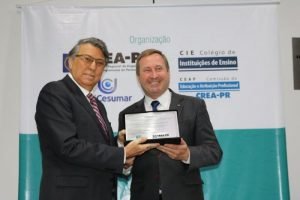 O Reitor da Unicesumar Wilson Matos, recebendo uma placa em agradecimento por sediar o evento, das mãos do Presidente do Crea- PR Joel Krieger. 